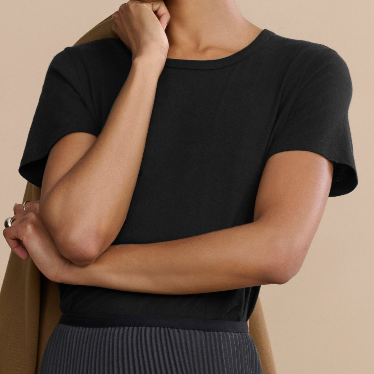 Woman wearing a black top with a beige background