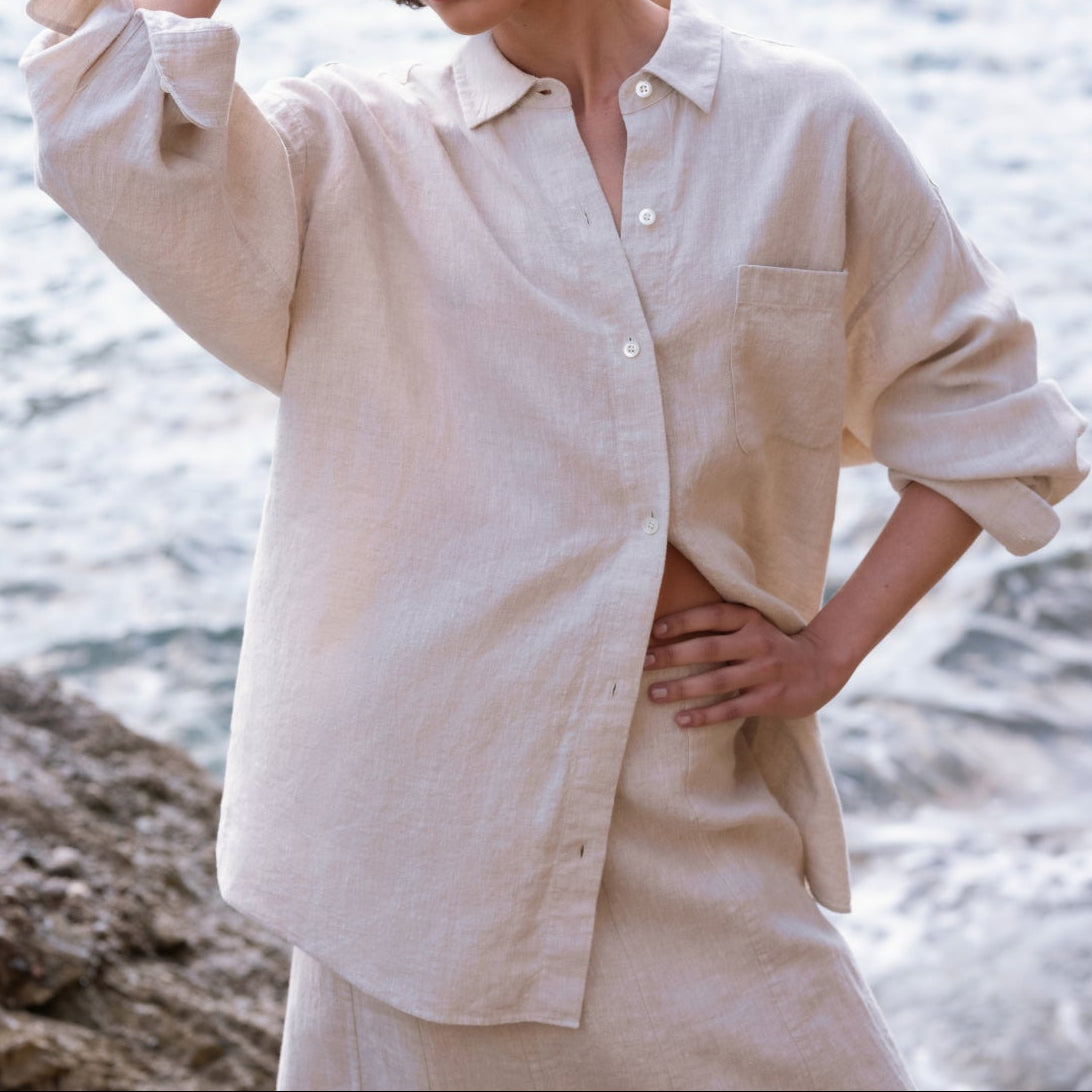 Woman wearing a beige shirt and skirt by the water