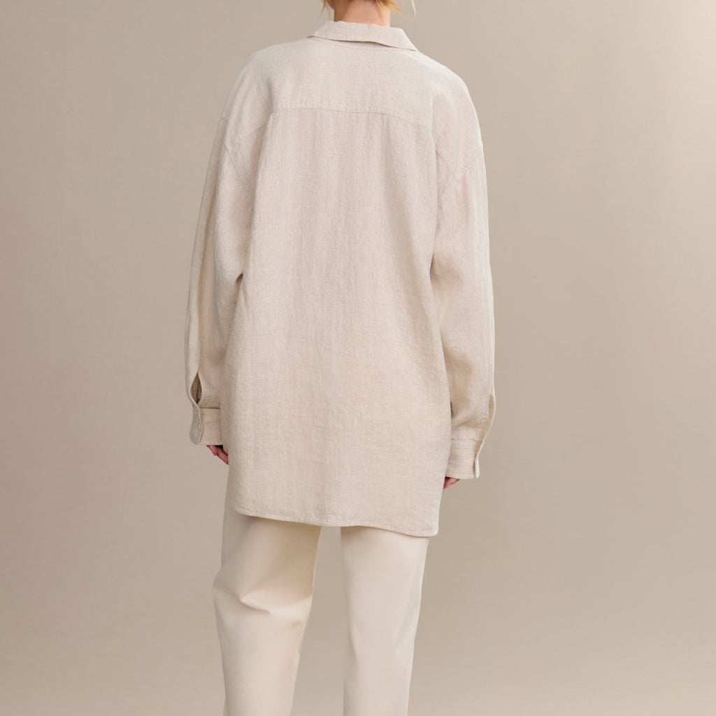Person wearing a beige coat and pants on a plain background