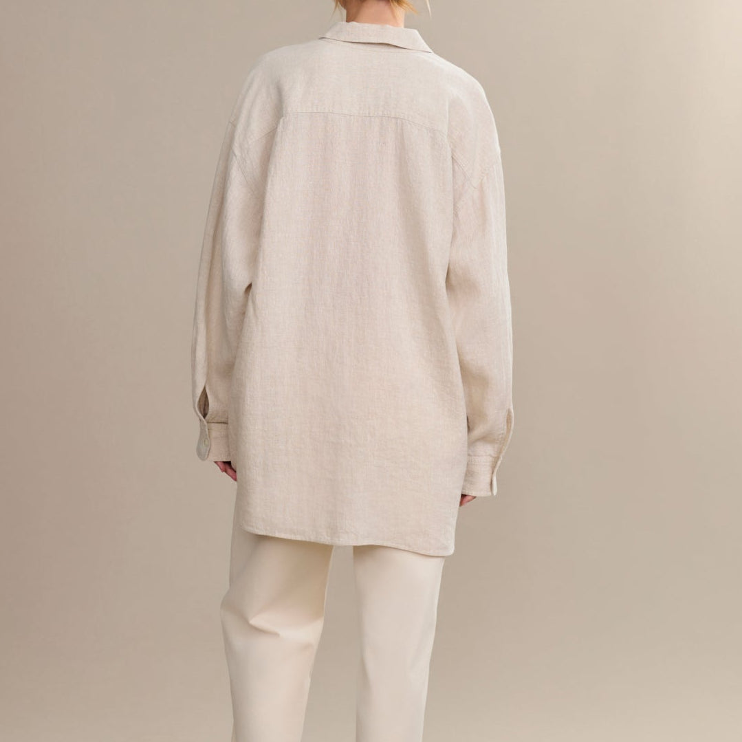 Person wearing a beige coat and pants on a plain background