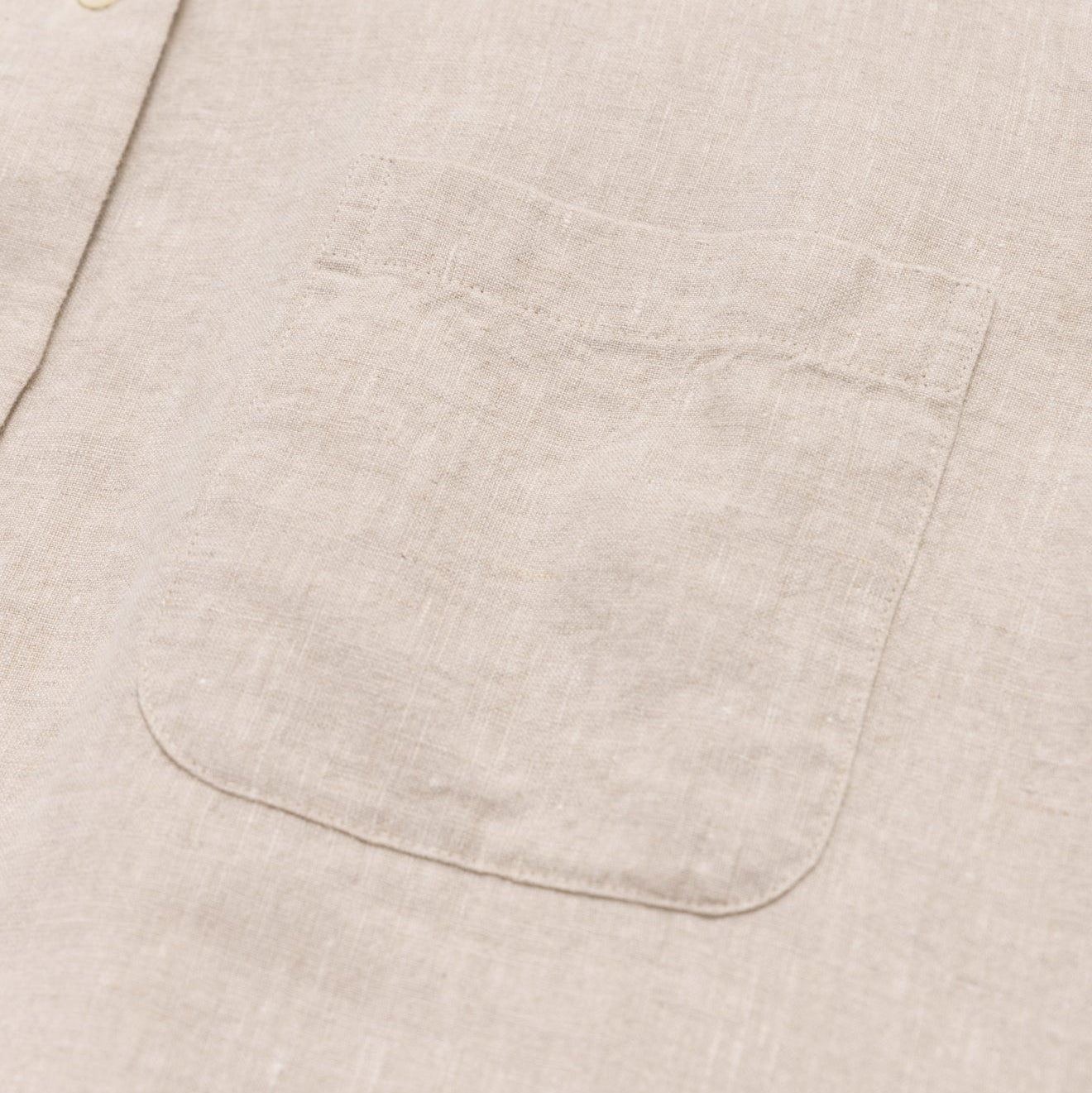 Close-up of a beige fabric pocket on a light beige background