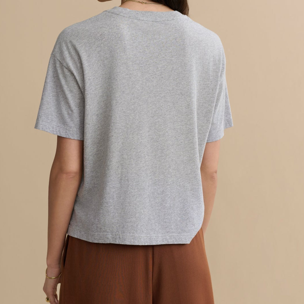 Person wearing a gray t-shirt and brown pants on a beige background