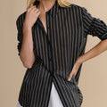 Woman wearing a black and white striped shirt against a beige background