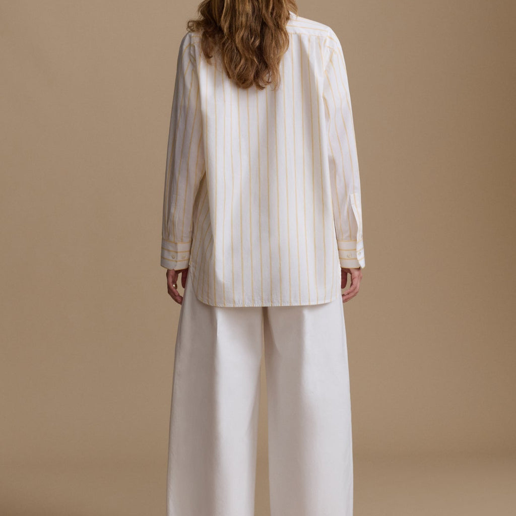 Woman wearing a white outfit with a beige background
